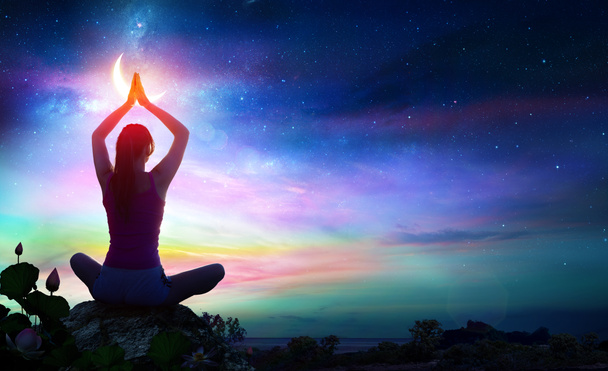 Frau macht Yoga mit Lotusblumen und Chakra-Farbverläufen - spirituelle Kontemplation - Foto, Bild