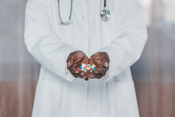 доктор держит цветные таблетки
 - Фото, изображение