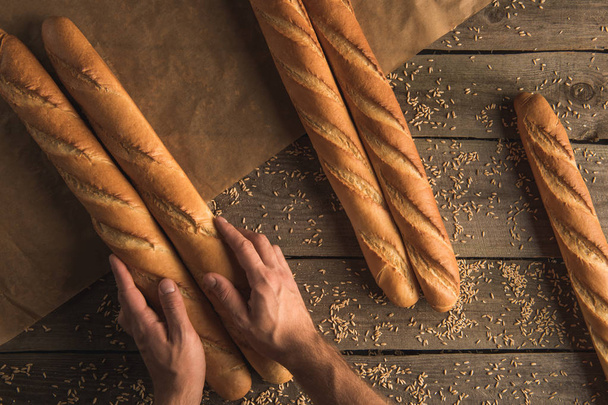 person packing baguettes - Photo, Image