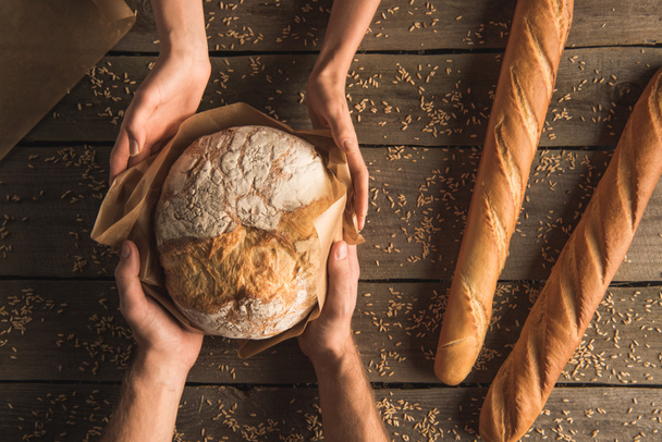 whole wheat bread in hands - Valokuva, kuva