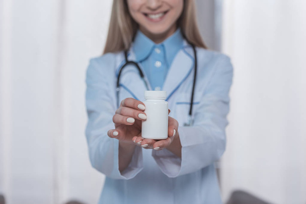 doctor showing plastic jar of pills - Foto, Bild