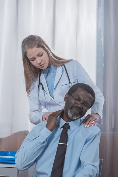 Lekarz bada pacjenta szyi - Zdjęcie, obraz
