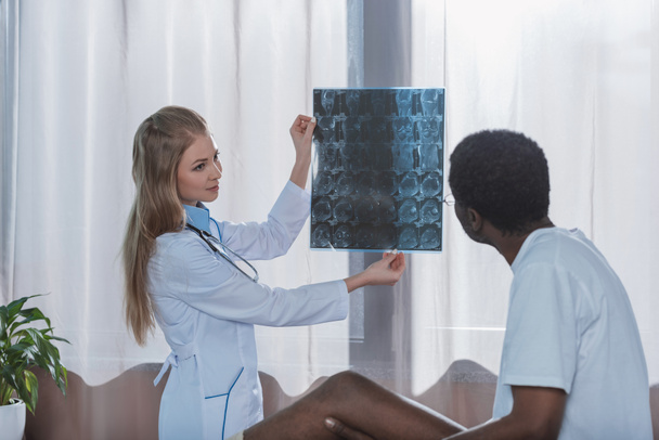 Medico che mostra i raggi X al paziente
  - Foto, immagini