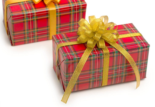 Pair of red and green checkered gift boxes with gold ribbon bows - Fotografie, Obrázek