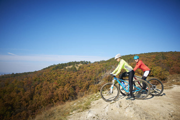 Two female cyclist enjoying the beautiful scenery while out mountain biking. - Foto, imagen