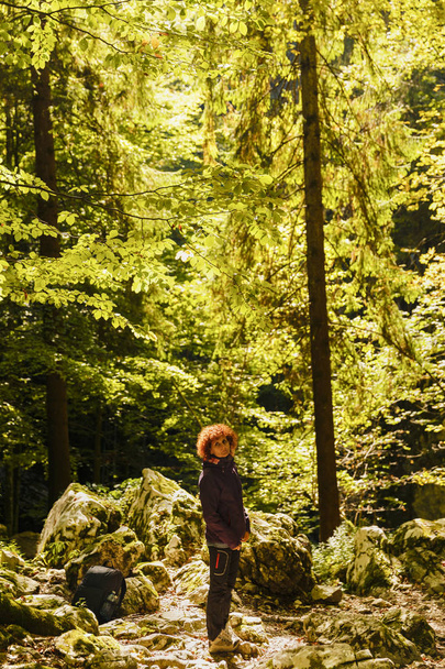 Γυναίκα πεζοπόρος με σακίδιο σε ένα μονοπάτι μέσα στο δάσος - Φωτογραφία, εικόνα