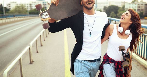  attractive couple carrying skateboards - Foto, Bild
