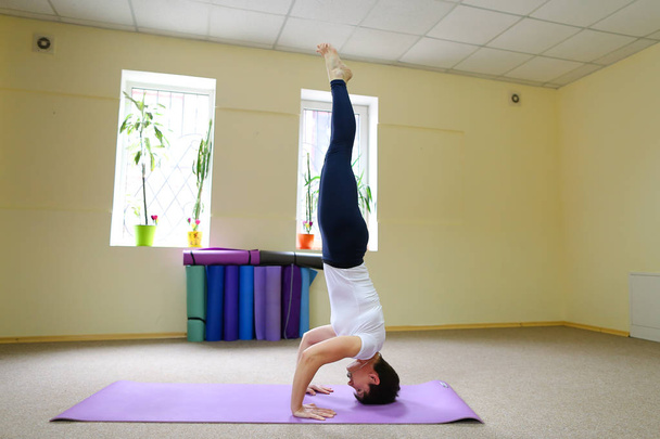 Mujer de aspecto europeo dedicada al yoga en gimnasio
. - Foto, imagen