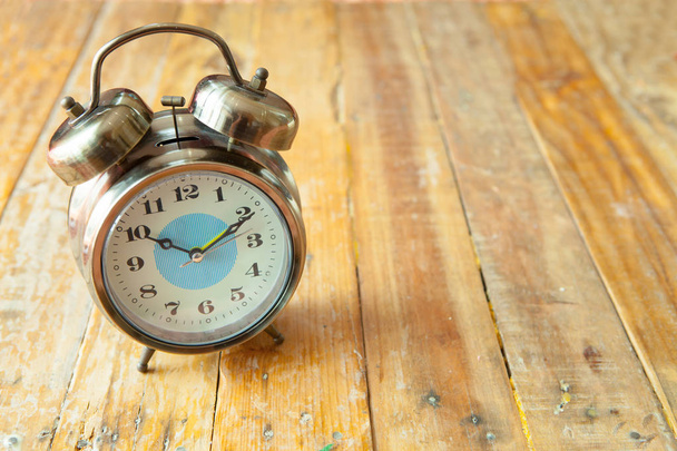 Big vintage alarm clock with bells, painted antique wooden backg - Photo, Image