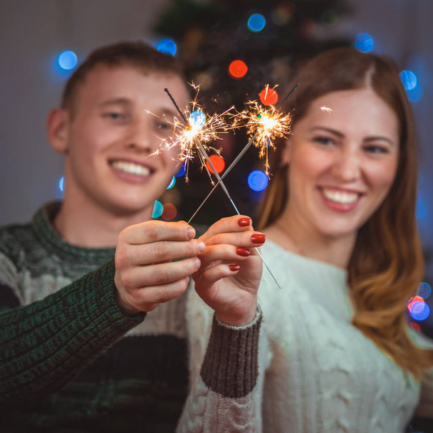 Christmas portrait of a loving couple. Man and woman on a Christmas tree background - Photo, Image