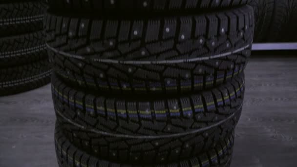 Winter tire on the background of racks with tires. - Footage, Video