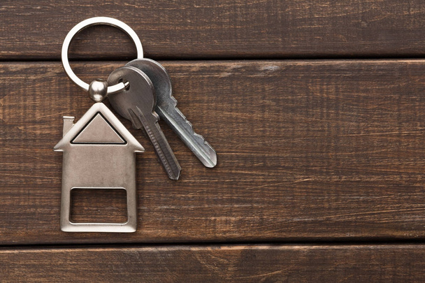 Bunch of keys with house shaped keychain on brown wood - Photo, Image