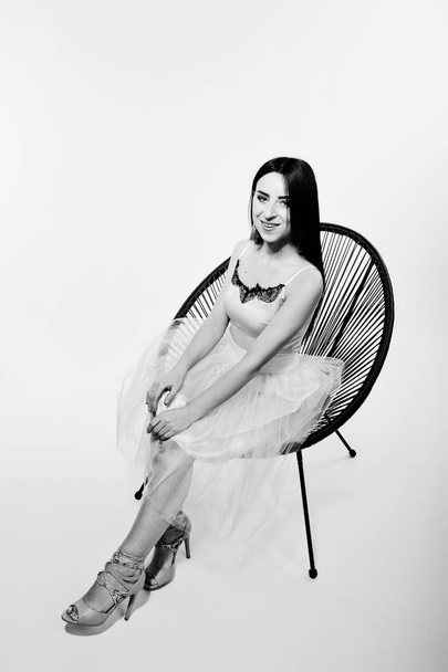 Portrait of brunette girl on beige dress with chair isolated on  - 写真・画像