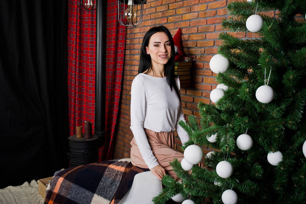 Brunette girl in dress posed near new year tree with christmas d - Fotó, kép
