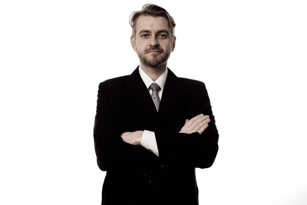 Hombre de negocios sonriente de pie con los brazos cruzados aislados sobre fondo blanco
 - Foto, imagen