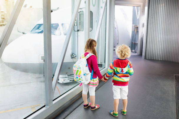 Kinder reisen und fliegen. Kind im Flugzeug am Flughafen - Foto, Bild