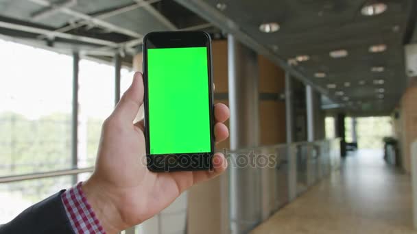 Ręka trzymająca telefon z zielonym ekranem - Materiał filmowy, wideo
