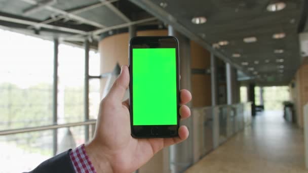 Ręka trzymająca telefon z zielonym ekranem - Materiał filmowy, wideo