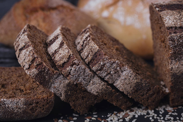 Assortment of baked bread on dark background.  - Photo, image