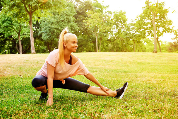 Young woman stretching on the field - Photo, Image