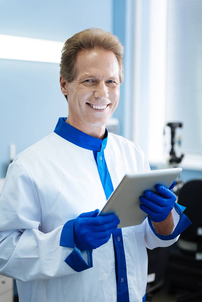 Inspired smiling scientist holding a tablet - Valokuva, kuva