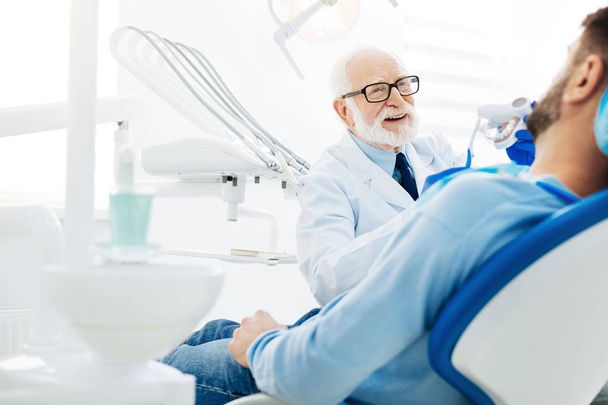 Professional stomatologist holding false teeth - Фото, изображение