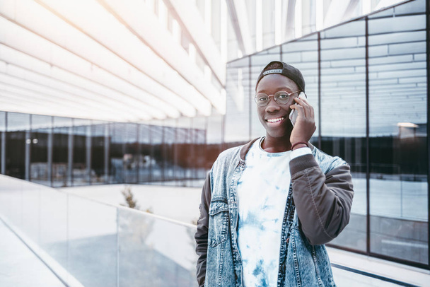 Black teenage studend talking on smartphone - Foto, Bild