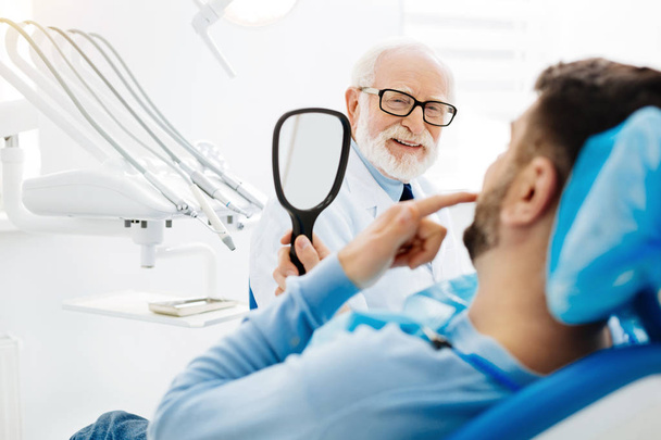 Optimistisch stomatologist met een patiënt - Foto, afbeelding