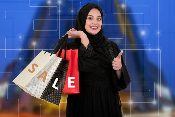 Arabian woman carrying shopping bags with sale symbol. - Φωτογραφία, εικόνα