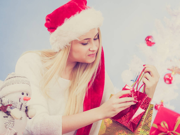 Woman in Santa hat preparing christmas gifts - Foto, afbeelding