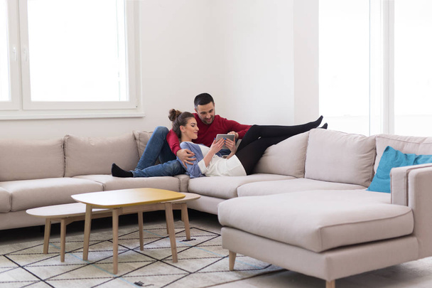 pareja relajante en casa usando tableta
 - Foto, imagen