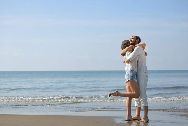 Romantic young couple on the beach kissing. - Photo, image