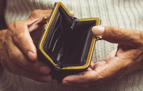 Elderly man holds in his hands an empty wallet. Vintage empty  - Foto, Bild
