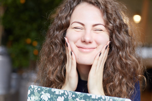 Positive body language emotions. Close-up of childish Caucasian female student with funky hair blowing cheeks bursting out laughing having joy looking happily into camera. Beautiful lady touches face. - Photo, Image