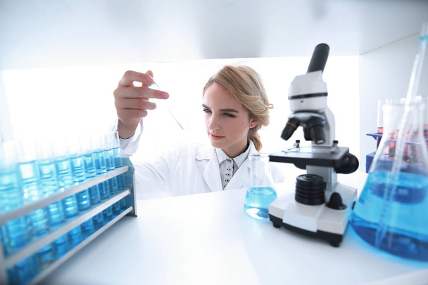 Young woman analyzing samples in a lab - Фото, зображення