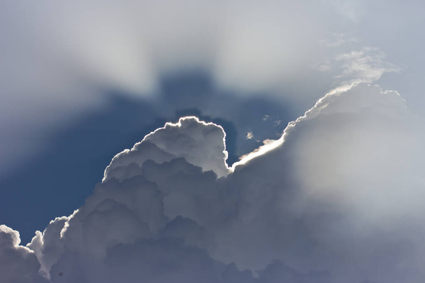 блакитне небо з білими хмарами і сонячними променями
 - Фото, зображення