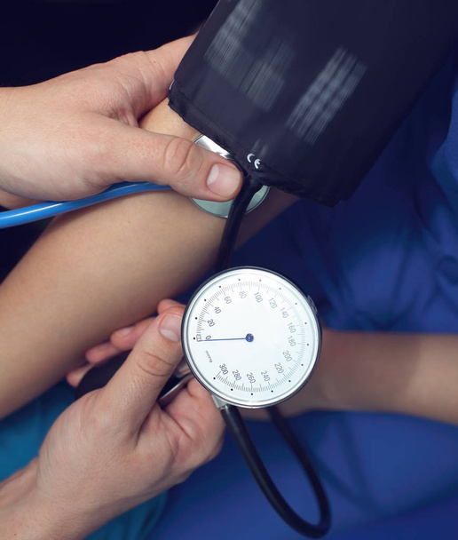 Travailleur médical mesure la pression artérielle au patient dans le
 - Photo, image