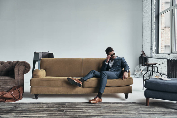 handsome man in suit sitting on sofa - Valokuva, kuva