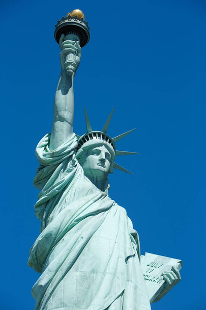 Statue of Liberty in a sunny day, blue sky in New York - Фото, изображение