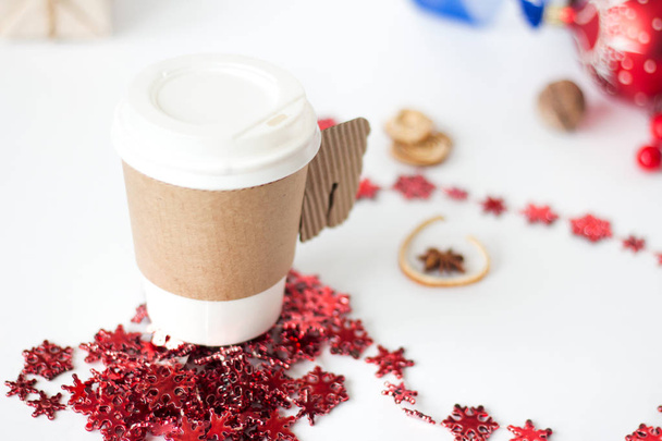 Una taza de café de papel, moca de menta, exhibida con decoraciones navideñas sobre fondo blanco
 - Foto, Imagen
