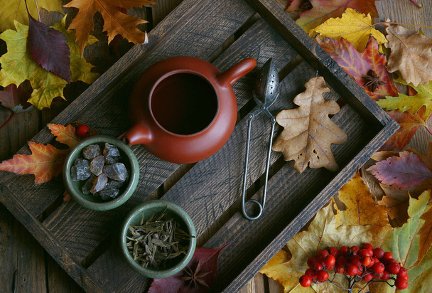 Autumn tea, Teapot on a wooden background, Autumn leaves - Fotoğraf, Görsel
