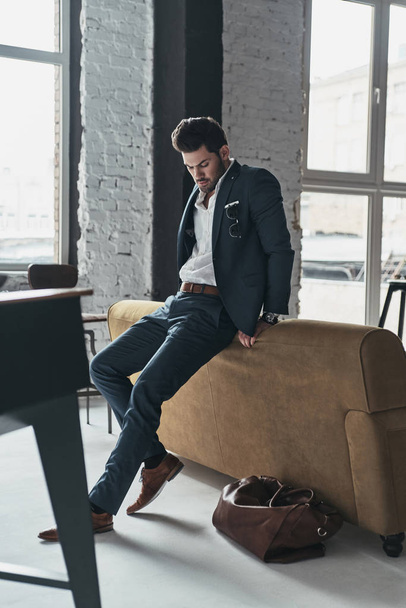 businessman in suit leaning on sofa - Zdjęcie, obraz
