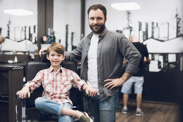 The boy is sitting in the hairdresser's barber shop. - Foto, imagen