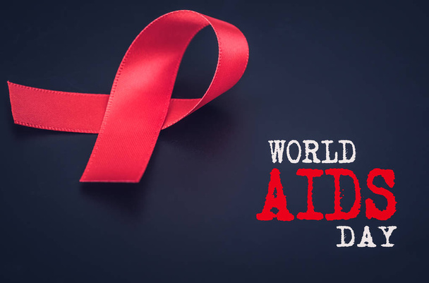 Primo piano consapevolezza nastro rosso su sfondo nero per la giornata mondiale dell'AIDS
 - Foto, immagini