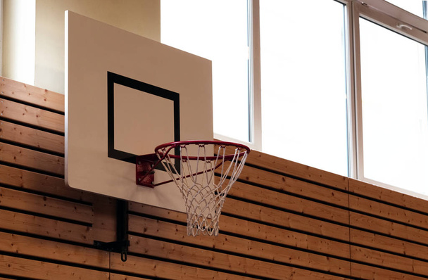 kosárlabda háló és keret egy iskolai tornaterem sport hall alacsony szög szelektív összpontosít. Vértes kosárlabda hoop háttér. - Fotó, kép