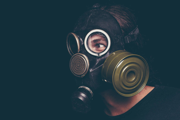 Hombre superviviente post apocalíptico con máscara de gas sobre fondo negro, ojos aterradores
 - Foto, imagen