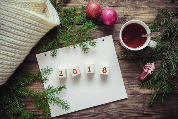 Image romantique d'hiver pour célébrer la nouvelle année 2018 avec une feuille de papier, une tasse de thé et des branches d'arbre de Noël
 - Photo, image
