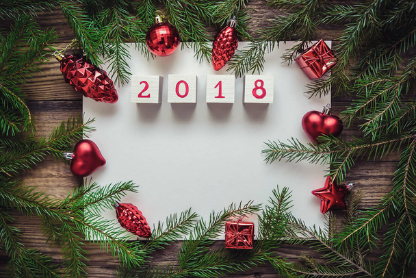Weihnachtlicher Hintergrund mit Blatt Papier, Spielzeug, Tannenzweigen und einem guten neuen Jahr 2018 - Foto, Bild