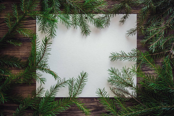 Christmas wooden background with sheet of paper and fir branches - Photo, Image