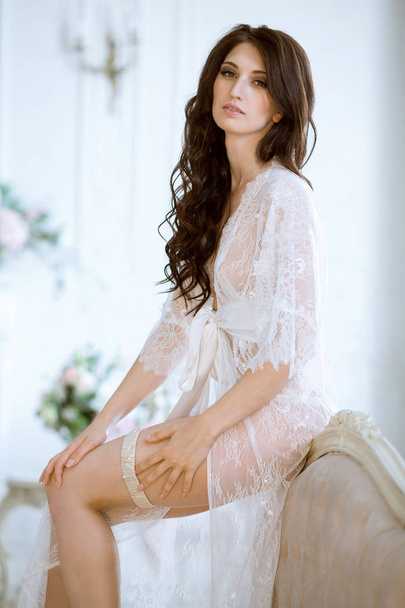 Beautiful sexy lady in elegant white robe - Фото, зображення